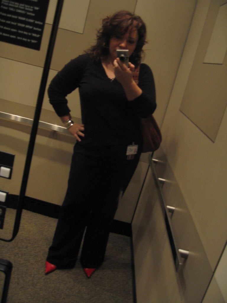 Alison Gary of Wardrobe Oxygen taking a mirror selfie of her work outfit in the mirrored walls of the building elevator