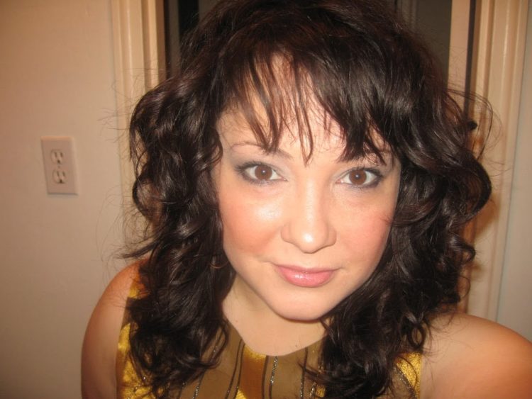 Alison Gary with wavy dark brown hair and smoky eye makeup getting ready for a night out in MIami
