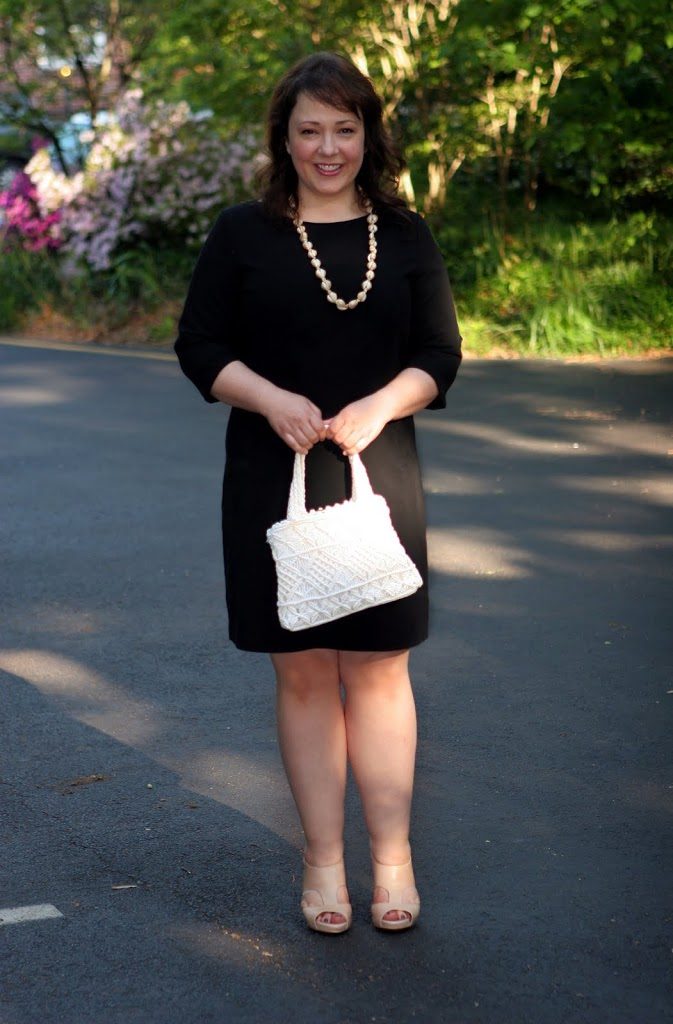 What I Wore Friday: Sofft Pavia Sandal with Black and Vintage Accessories 1 Alison Gary of Wardrobe Oxygen in a black bracelet sleeve sheath dress holding a white crocheted vintage handbag