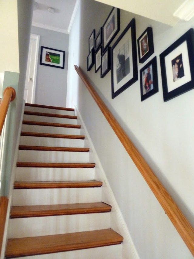 a hallway in a 1940's rowhome in historic Greenbelt, Maryland with a collage of black frames holding family photos along the wall