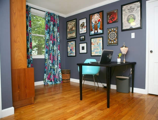 photo of a home office painted in Glidden Stormy Night with a black table desk and floral curtains