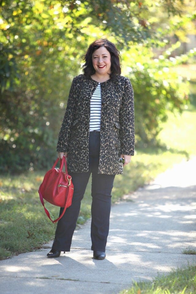   Alison Gary mixing leopard with stripes by pairing a leopard print collareless coat from Talbots over a striped Breton top, dark jeans, and a red satchel bag