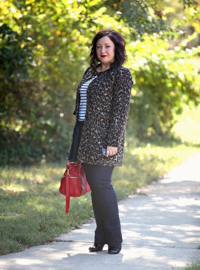   Alison Gary mixing leopard with stripes by pairing a leopard print collareless coat from Talbots over a striped Breton top, dark jeans, and a red satchel bag