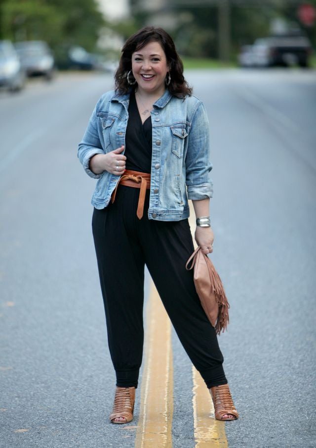 Wardrobe Oxygen featuring a black jersey jumpsuit, denim jacket, and cognac sandals and belt