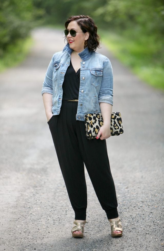 Wardrobe Oxygen wearing a Loveappella jumpsuit, J. Crew Factory denim jacket, and Love,Cortnie clutch bag