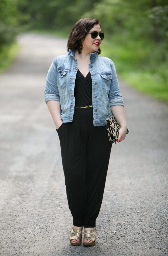 Wardrobe Oxygen wearing a Loveappella jumpsuit, J. Crew Factory denim jacket, and Love,Cortnie clutch bag