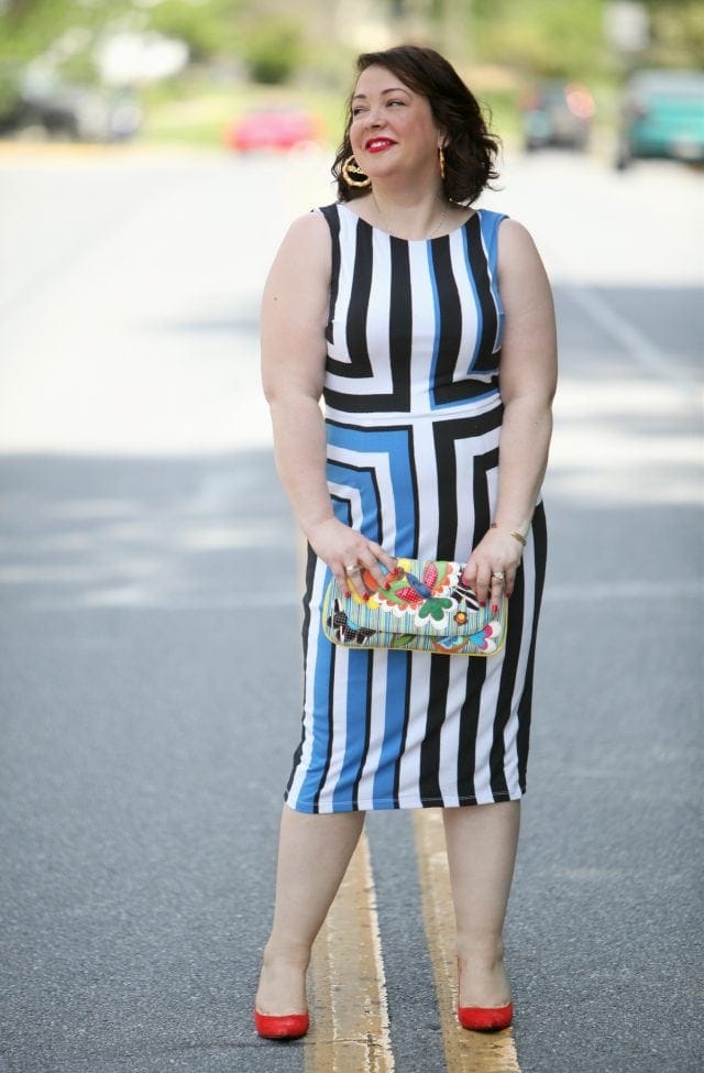 Wardrobe Oxygen in a Vince Camuto black, white, and blue graphic dress, Novica clutch, and orange Nine West pumps