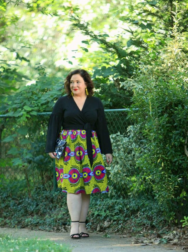 Wardrobe Oxygen in an ELOQUII wrap top with bell sleeves and an yellow Ankara midi skirt