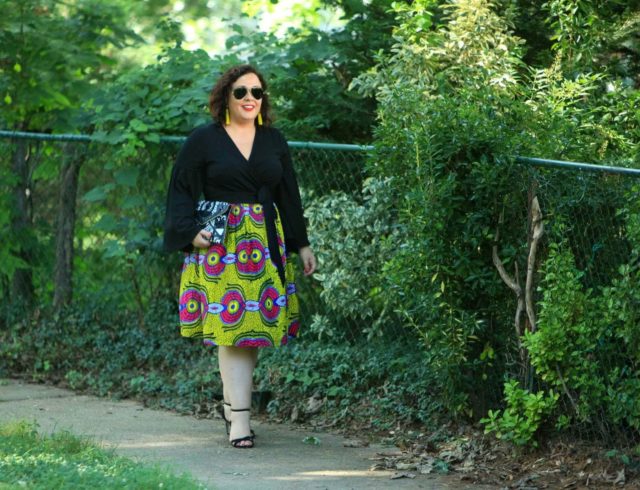 Wardrobe Oxygen in an ELOQUII wrap top with bell sleeves and an yellow Ankara midi skirt
