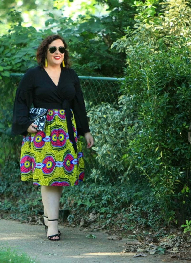 Wardrobe Oxygen in an ELOQUII wrap top with bell sleeves and an yellow Ankara midi skirt