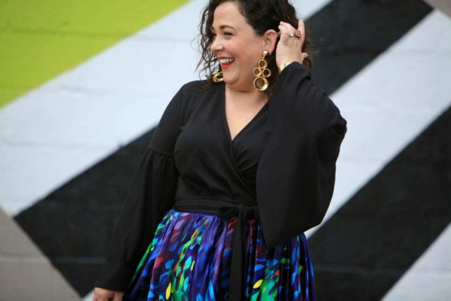 over 40 blogger alison gary of wardrobe oxygen in an ELOQUII wrap top, vintage earrings, and a colorful custom made maxi skirt
