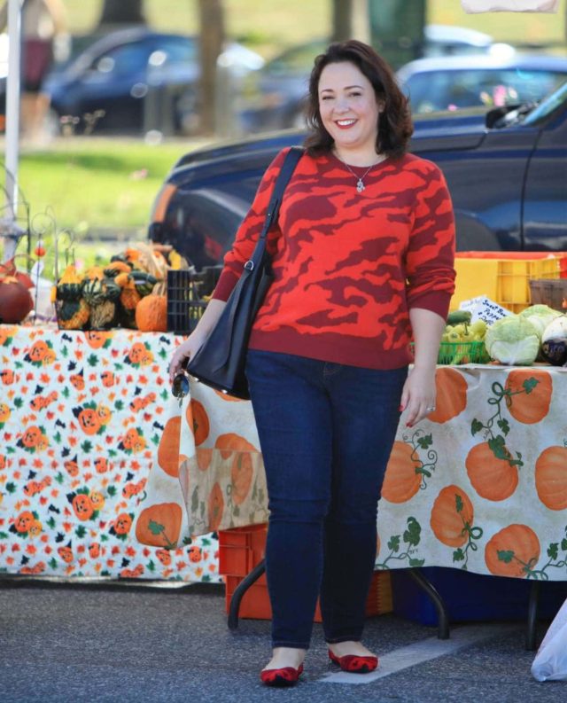 Wardrobe Oxygen in a red camo print cabi sweater, dark JAG jeans, and Rothy's flats