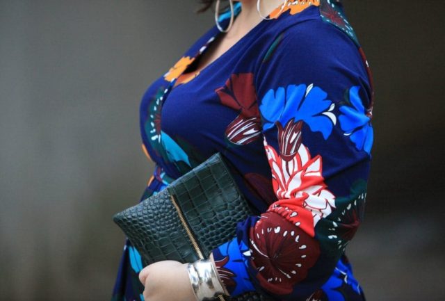 Wardrobe Oxygen in an ELOQUII dark floral maxi dress with an Elloq black faux fur coat and Clare V green crocs clutch