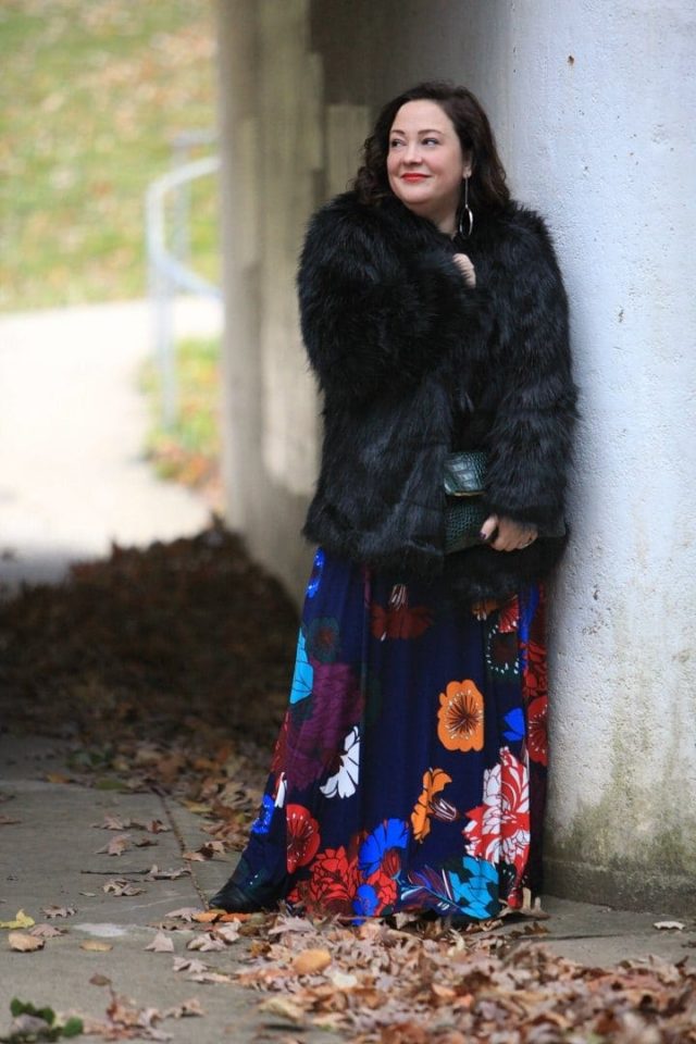 Wardrobe Oxygen in an ELOQUII dark floral maxi dress with an Elloq black faux fur coat and Clare V green crocs clutch