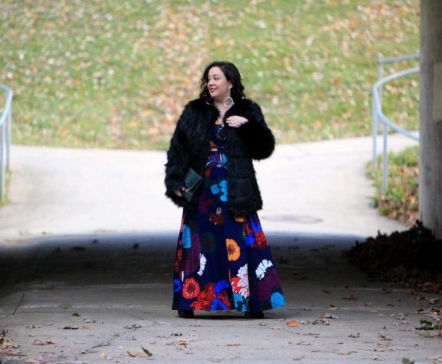 Wardrobe Oxygen in an ELOQUII dark floral maxi dress with an Elloq black faux fur coat and Clare V green crocs clutch