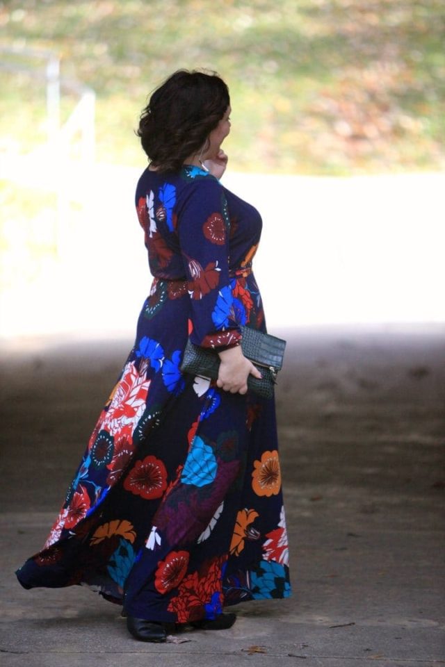 Wardrobe Oxygen in an ELOQUII dark floral maxi dress with an Ellos black faux fur coat and Clare V green crocs clutch