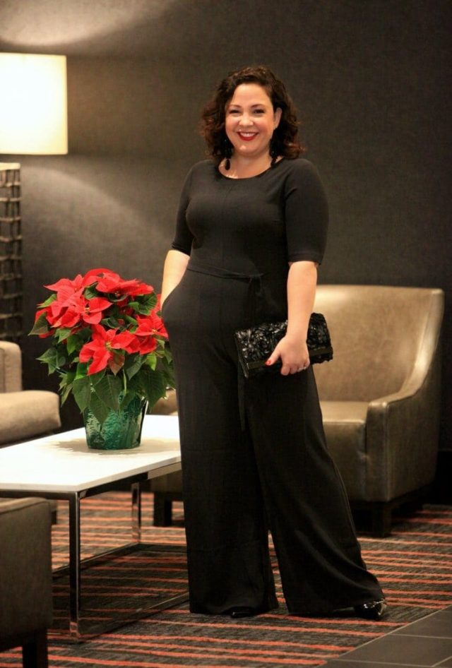 Wardrobe Oxygen in a Simply Vera Vera Wang jumpsuit, earrings, and clutch dressed for a cocktail party