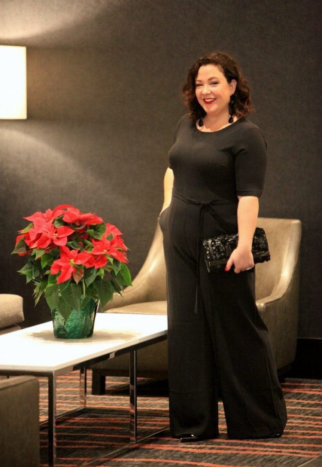 Wardrobe Oxygen in a Simply Vera Vera Wang jumpsuit, earrings, and clutch dressed for a cocktail party