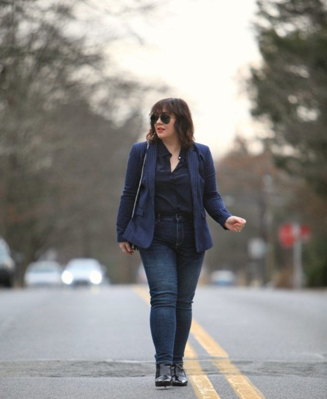 What I Wore: Old and New 1 Alison Gary of Wardrobe Oxygen walking down a city street wearing a navy pinstripe blazer from Banana Republic with Universal Standard Seine jeans and black patent ankle booties