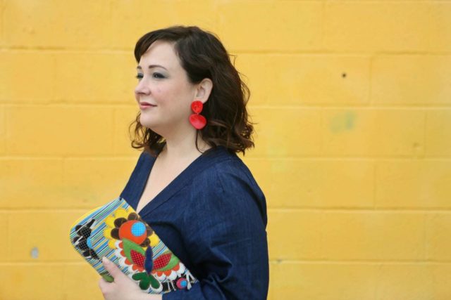 Wardrobe Oxygen in red lucite statement earrings from Nordstrom and a recycled patterned clutch bag from Novica - ELOQUII Denim Jumpsuit styled by popular Washington DC petite fashion blogger, Wardrobe Oxygen