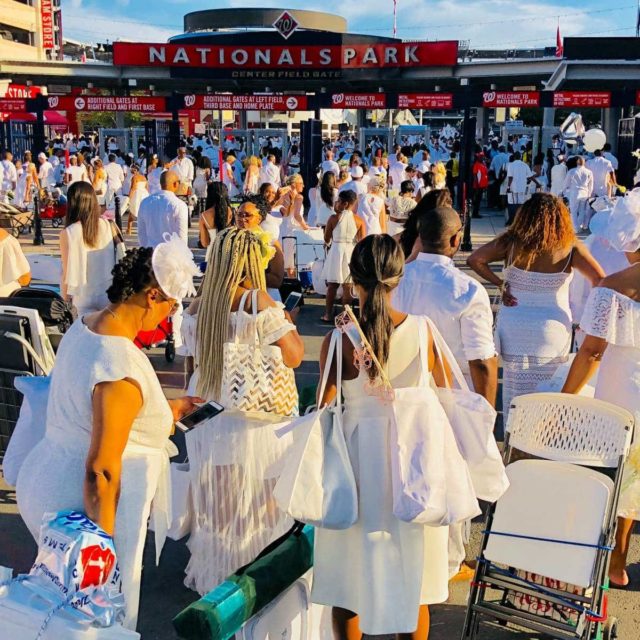 Individuals in white heading into Nationals Park in Washington DC for Dîner en Blanc