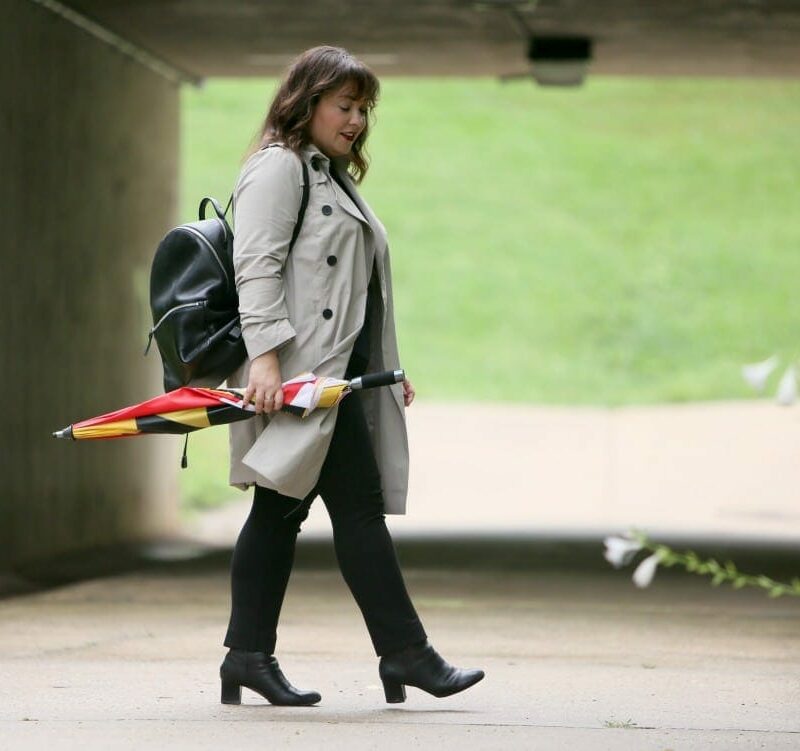 Alison Gary of Wardrobe Oxygen in a Universal Standard Trench Coat with Maryland Flag golf umbrella, navy Talbots cashmere sweater and black Chico's ponte pants