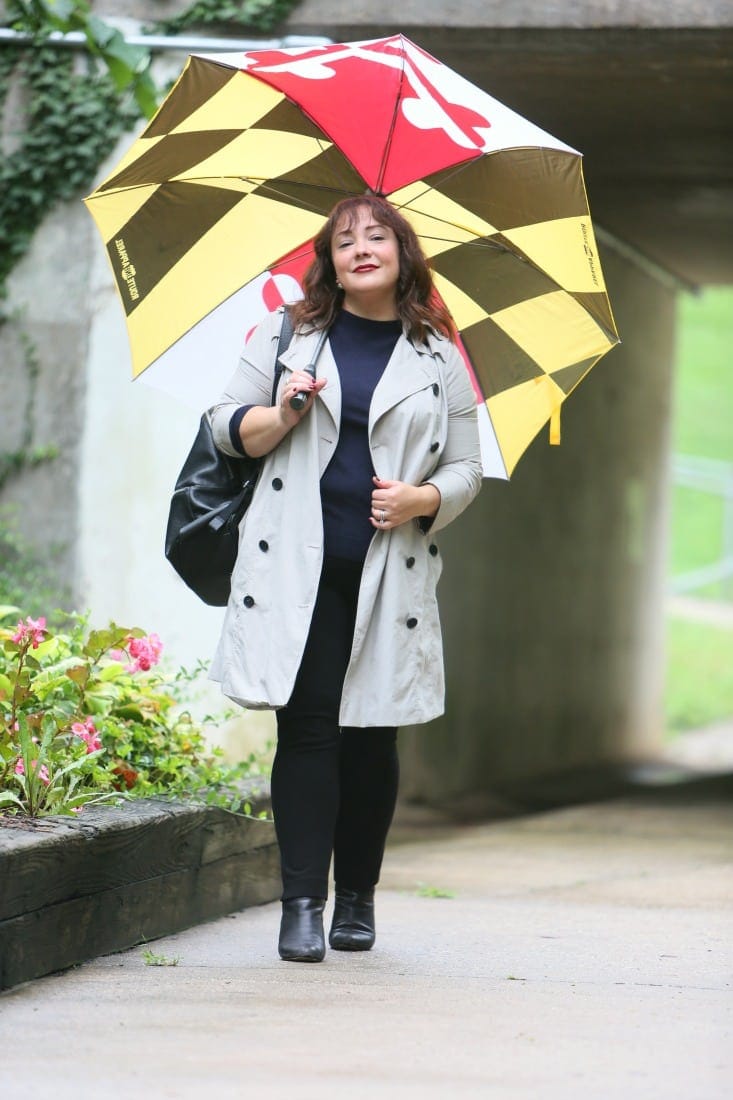 Alison Gary of Wardrobe Oxygen in a Universal Standard Trench Coat with Maryland Flag golf umbrella, navy Talbots cashmere sweater and black Chico's ponte pants