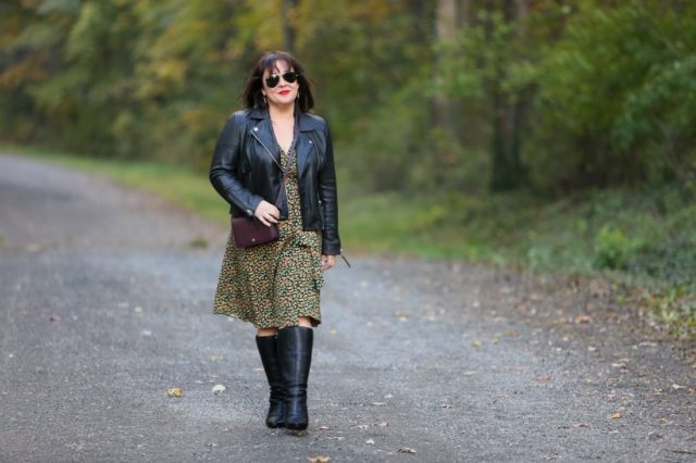 Wardrobe Oxygen in a petite black leather Moto jacket with a floral wrap dress, black heeled knee-high wide calf boots, and the Dagne Dover Small Andra Crossbody in Oxblood #dagnedover