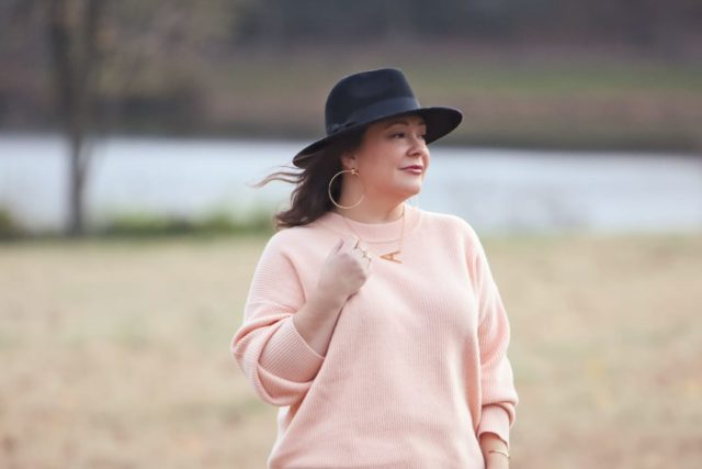 Wardrobe Oxygen in the And Comfort Fika sweater in peach with cream wide leg cropped jeans from Universal Standard, a black felt fedora from Ann Taylor, gold Faye Knocker hoop earrings from Jenny Bird, and black Clarks ankle booties