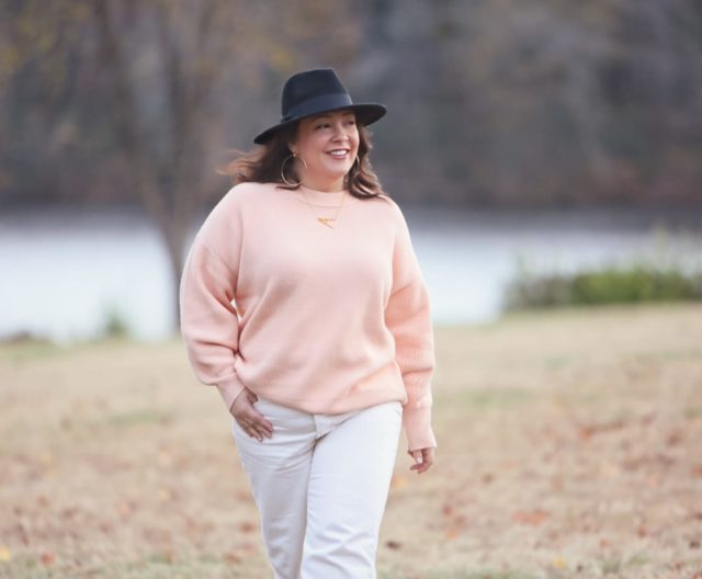 Wardrobe Oxygen in the And Comfort Fika sweater in peach with cream wide leg cropped jeans from Universal Standard, a black felt fedora from Ann Taylor, gold Faye Knocker hoop earrings from Jenny Bird, and black Clarks ankle booties