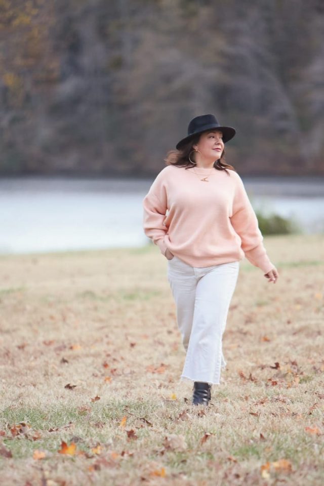 Wardrobe Oxygen in the And Comfort Fika sweater in peach with cream wide leg cropped jeans from Universal Standard, a black felt fedora from Ann Taylor, gold Faye Knocker hoop earrings from Jenny Bird, and black Clarks ankle booties