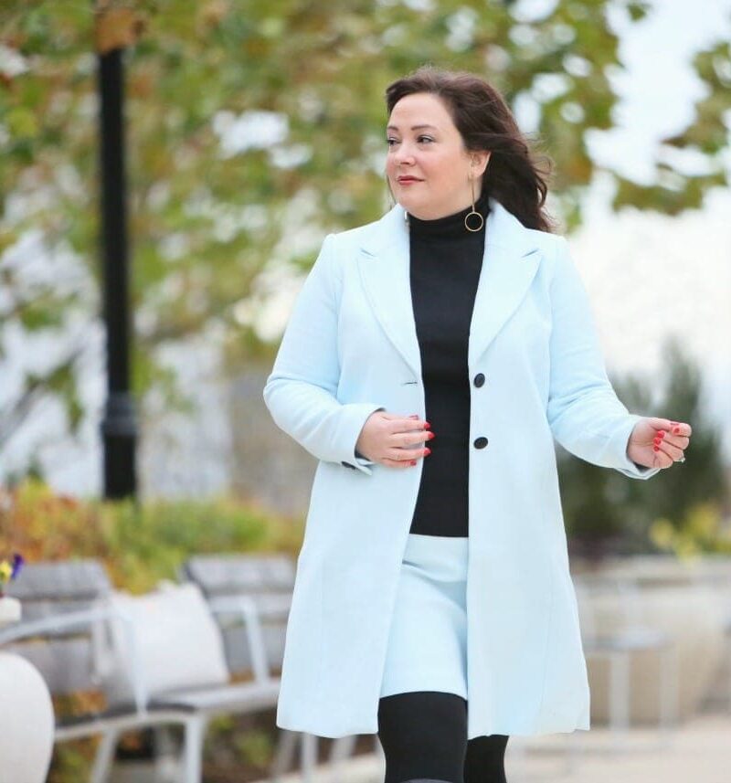 An ice blue skirt suit from White House Black Market styled with black boots and turtleneck as seen on Alison Gary of Wardrobe Oxygen