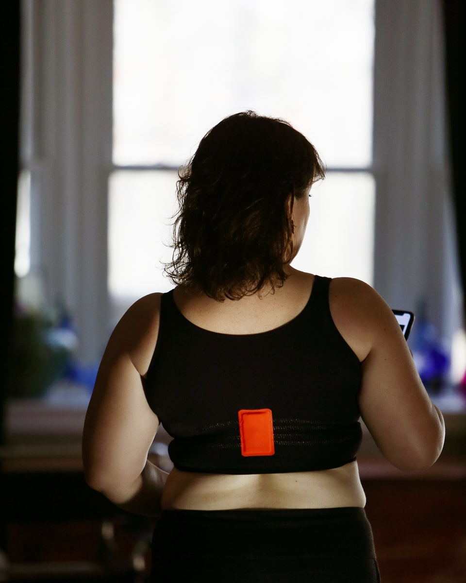 The back of the Soma INNOFIT bra, showing the orange battery pack and how it fits in the middle of the back