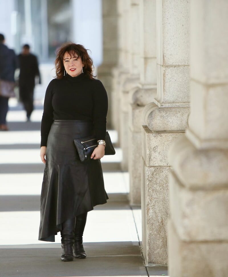 Wardrobe Oxygen in a black cashmere turtleneck, black leather asymmetrical skirt from Topshop, and silver Jenny Bird Trust Hoops with black knee-high wide calf heeled boots #over40fashion #40plusstyle #petitefashionblogger