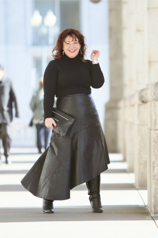 Wardrobe Oxygen in a black cashmere turtleneck, black leather asymmetrical skirt from Topshop, and silver Jenny Bird Trust Hoops with black knee-high wide calf heeled boots #over40fashion #40plusstyle #petitefashionblogger