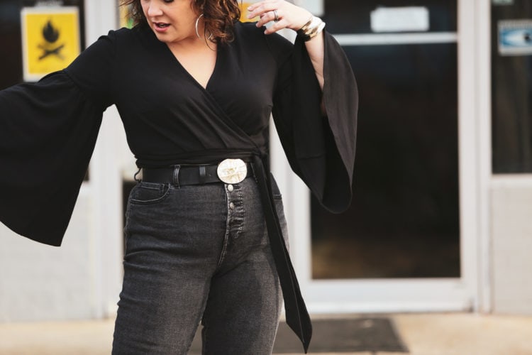 Black cropped wrap top with bell sleeves and Everlane jeans styled with an oversized silver and abalone belt