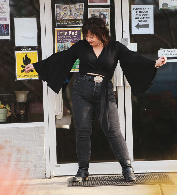 Black cropped wrap top with bell sleeves and Everlane jeans styled with an oversized silver and abalone belt