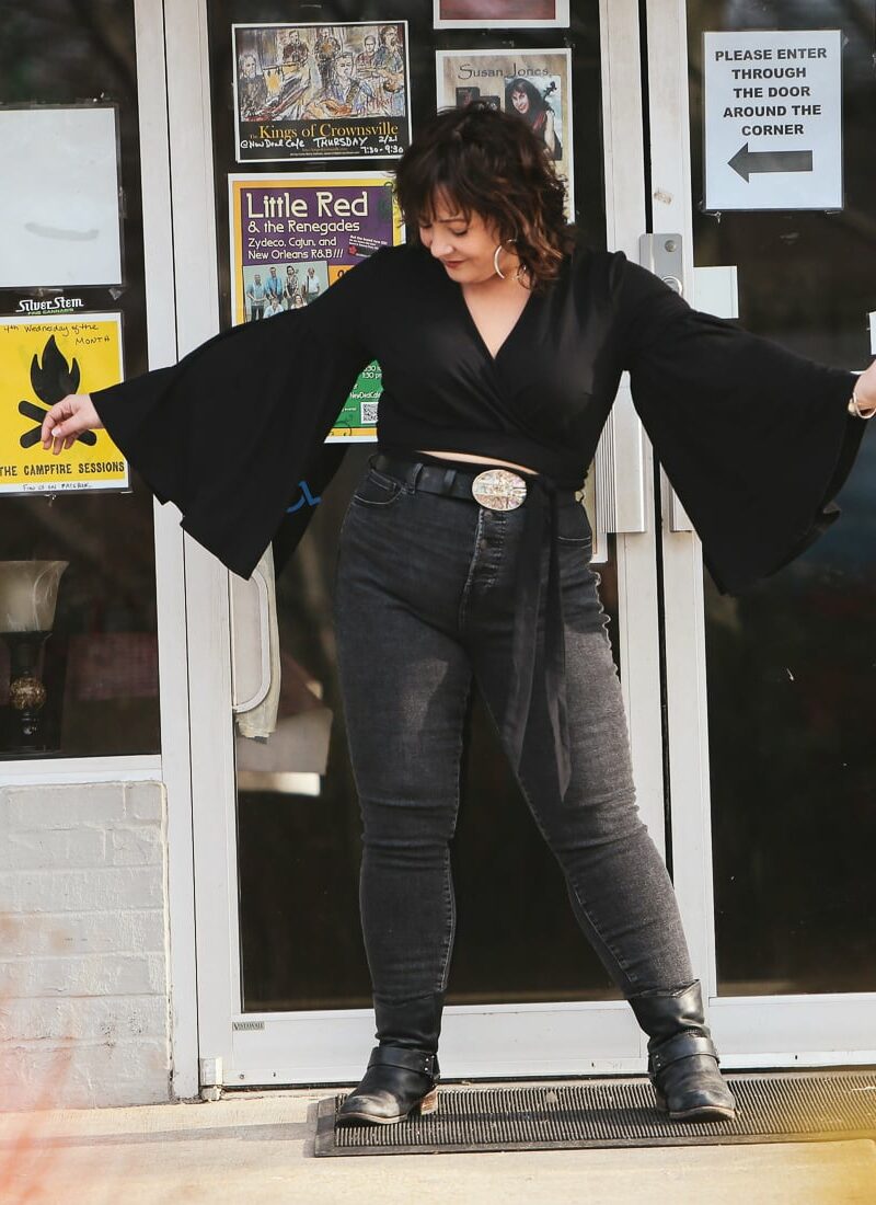 Black cropped wrap top with bell sleeves and Everlane jeans styled with an oversized silver and abalone belt