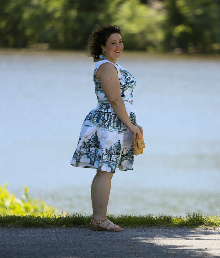 Rome-inspired printed fit and flare dress from Talbots styled with a woven straw clutch purse, Zara earrings, and Talbots wide width wedge sandals