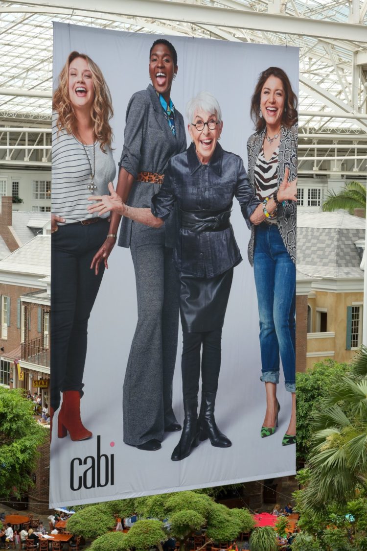 a poster depicting four women wearing cabi