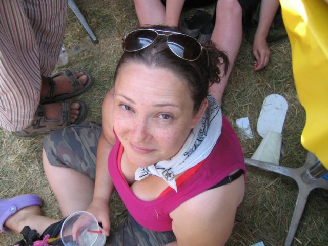 woman in pigtails sitting on the ground looking up at the camera