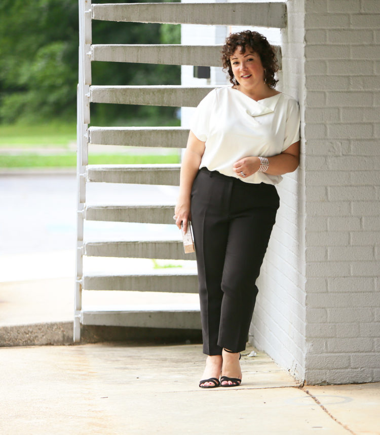 Woman in the Universal Standard Viva Boatneck Top in white with black tux-inspired ankle pants from Talbots.