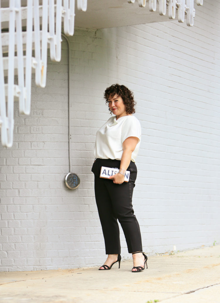 Woman in the Universal Standard Viva Boatneck Top in white with black tux-inspired ankle pants from Talbots.