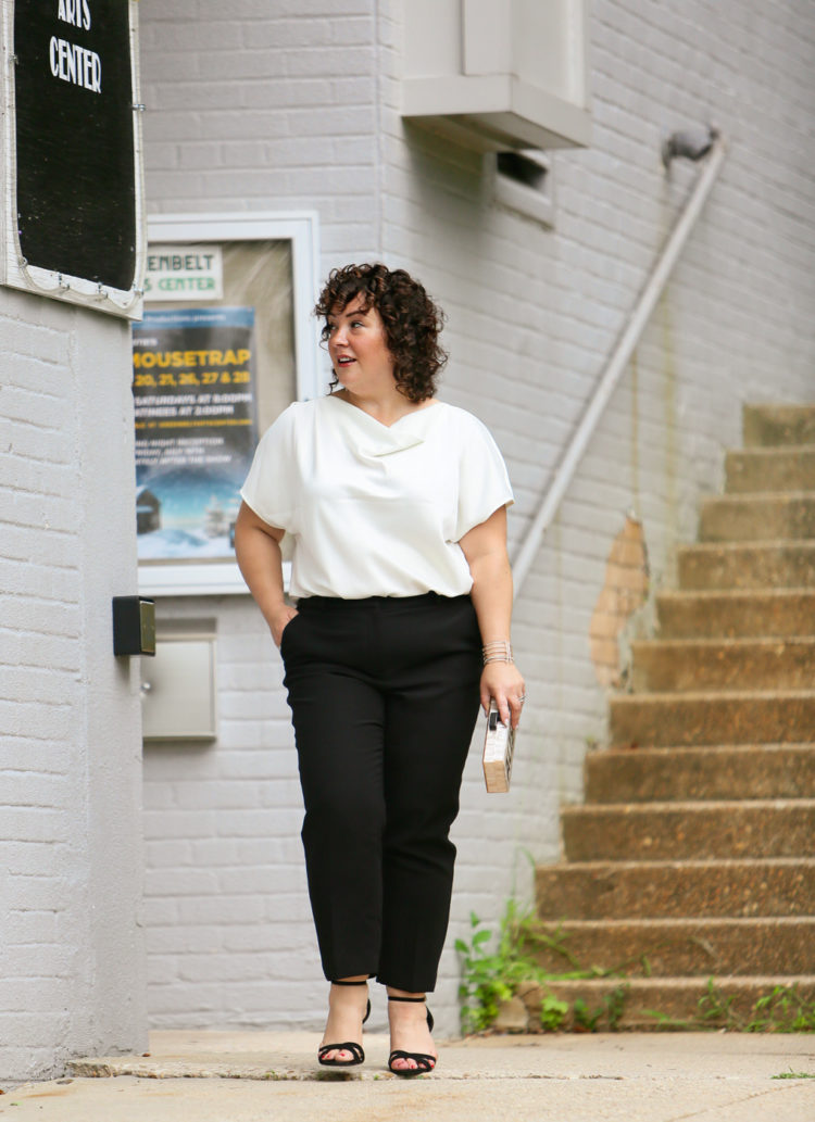 Woman in the Universal Standard Viva Boatneck Top in white with black tux-inspired ankle pants from Talbots.