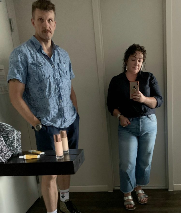 woman taking mirror selfie wearing navy linen shirt and cropped jeans