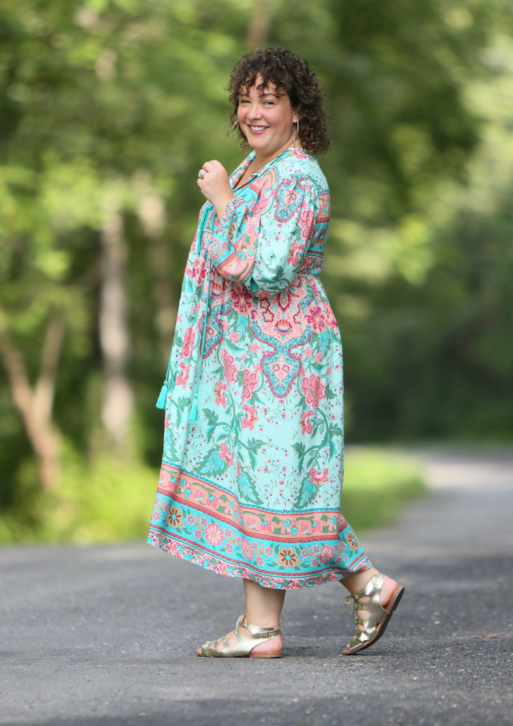 Alison in the green floral dress unbelted walking to the left