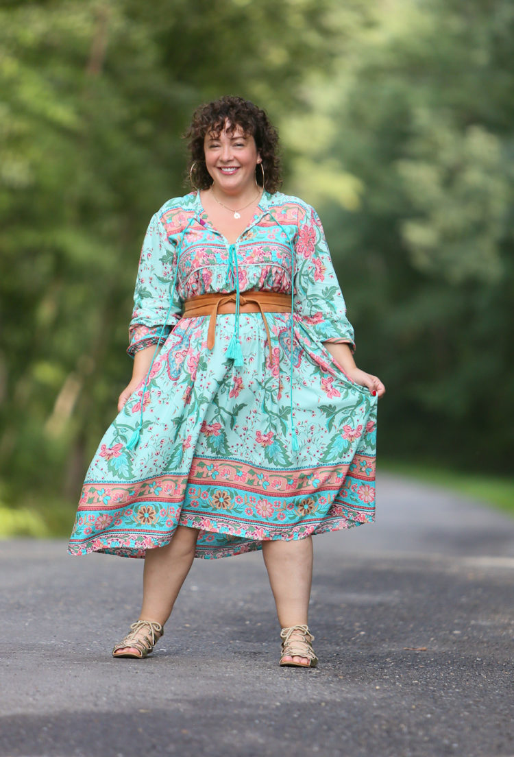 woman in a green floral dress cinched with a tan obi belt