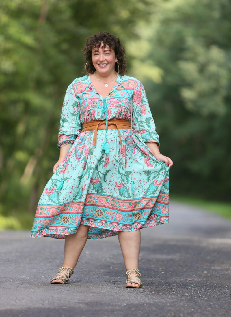 woman in a green floral dress cinched with a tan obi belt