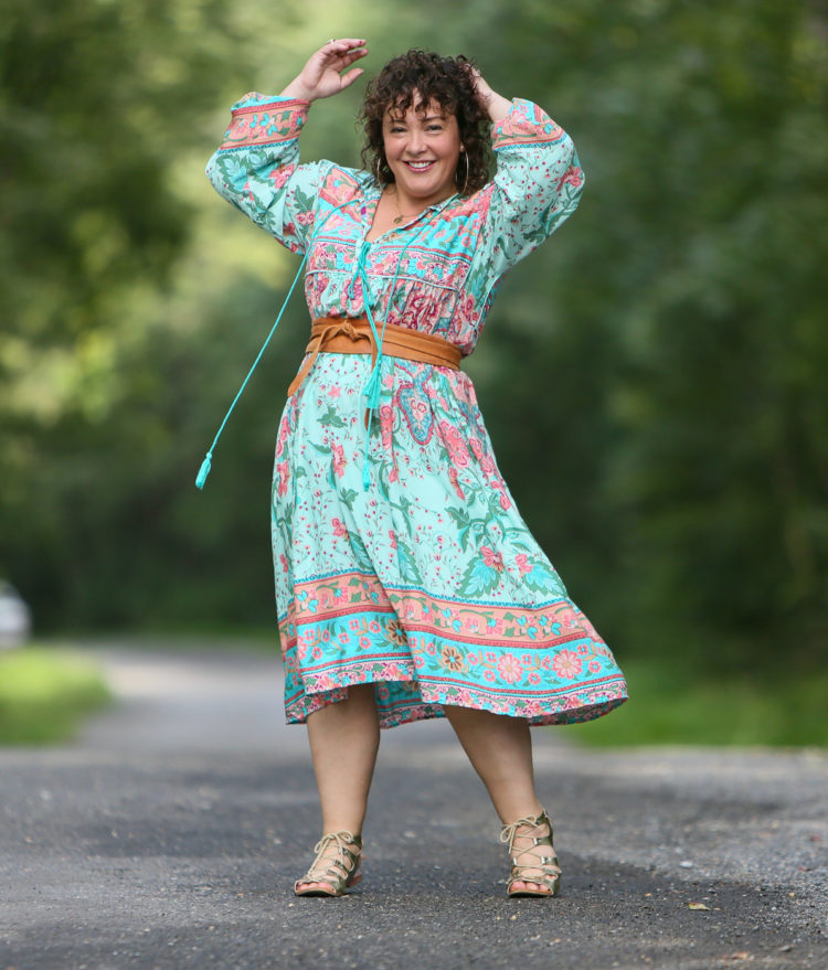 woman in light green floral dress cinched with a tan obi belt