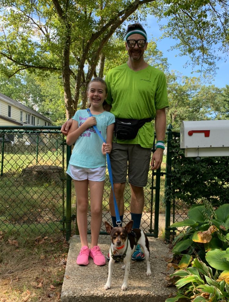 girl and her father dressed to go on a run with a dog on a leash